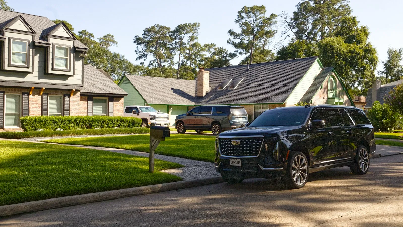 Casa com gramado e um carro estacionado na entrada da garagem